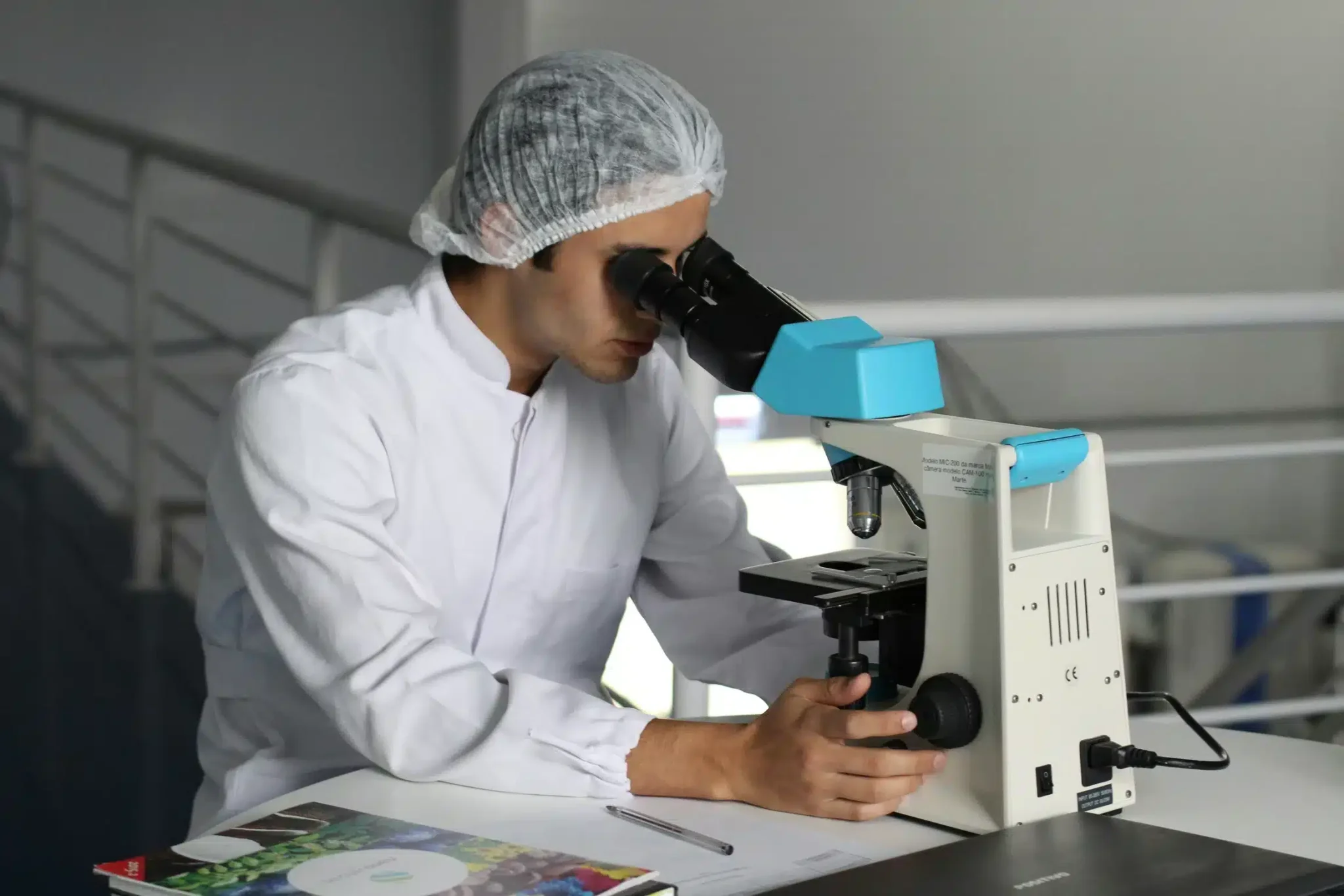 Laborant bei der Mikroskop-Analyse zur Qualitäts- und Rohstoffprüfung.