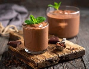 Selbst gemachter Schokopudding aus Rohkakao ist gesünder, da er mehr wertvolle Nährstoffe, Antioxidantien und Mineralstoffe wie Magnesium und Eisen enthält. Dies liegt daran, dass Rohkakao nicht geröstet wird, wodurch diese Nährstoffe nicht verloren gehen. Zudem kann Rohkakao die Stimmung verbessern, da er die Produktion von Endorphinen und Serotonin anregt. Er kann auch die Herzgesundheit fördern und aufgrund seines hohen Ballaststoffgehalts für ein langanhaltendes Sättigungsgefühl sorgen. Das zügelt den Appetit und kann bei der Gewichtskontrolle helfen.