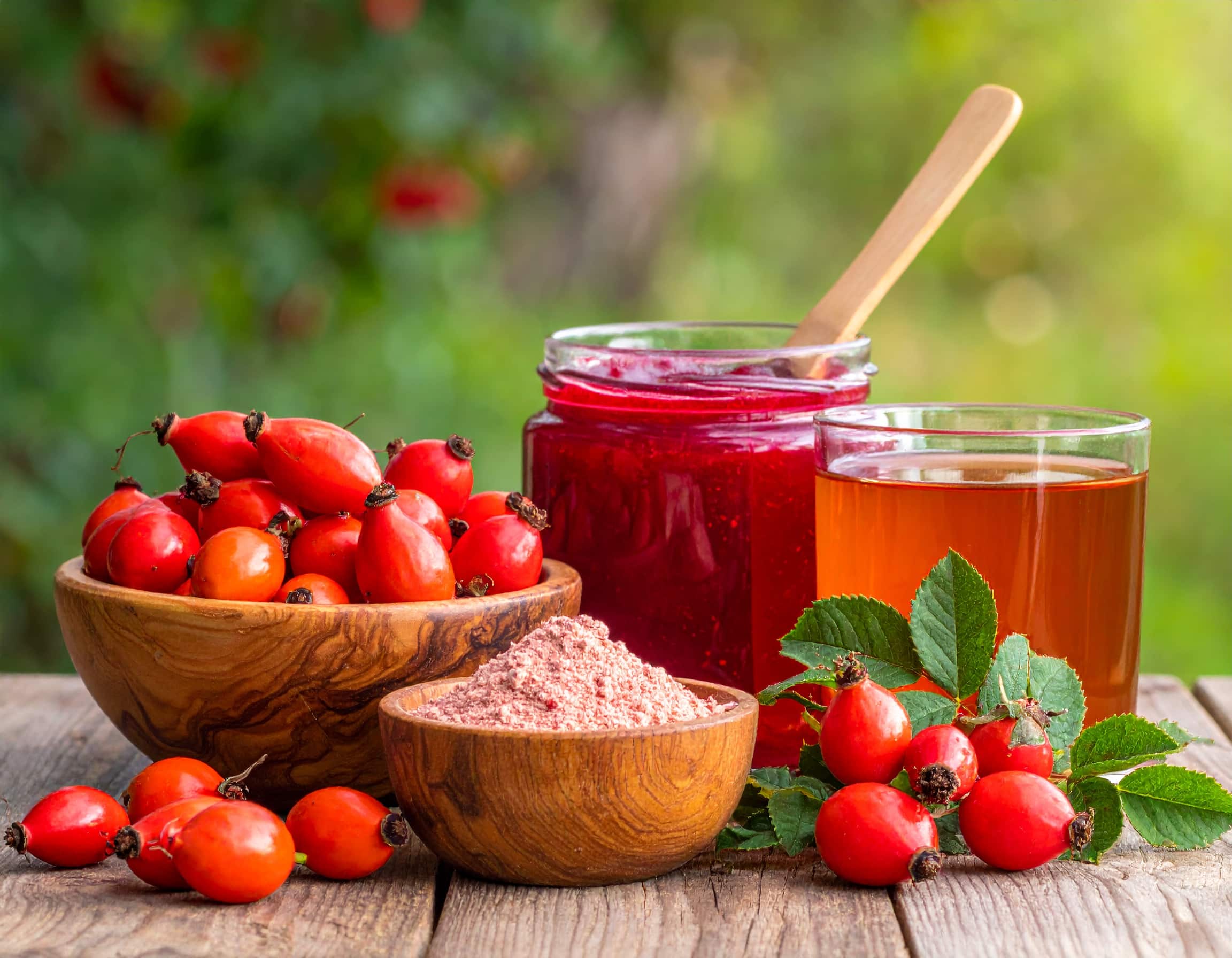 Verschiedene Formen der Hagebutte: Frische Hagebuttenfrüchte, feines Hagebuttenpulver und Hagebuttentee als reichhaltige, natürliche Quellen für Vitamin C.