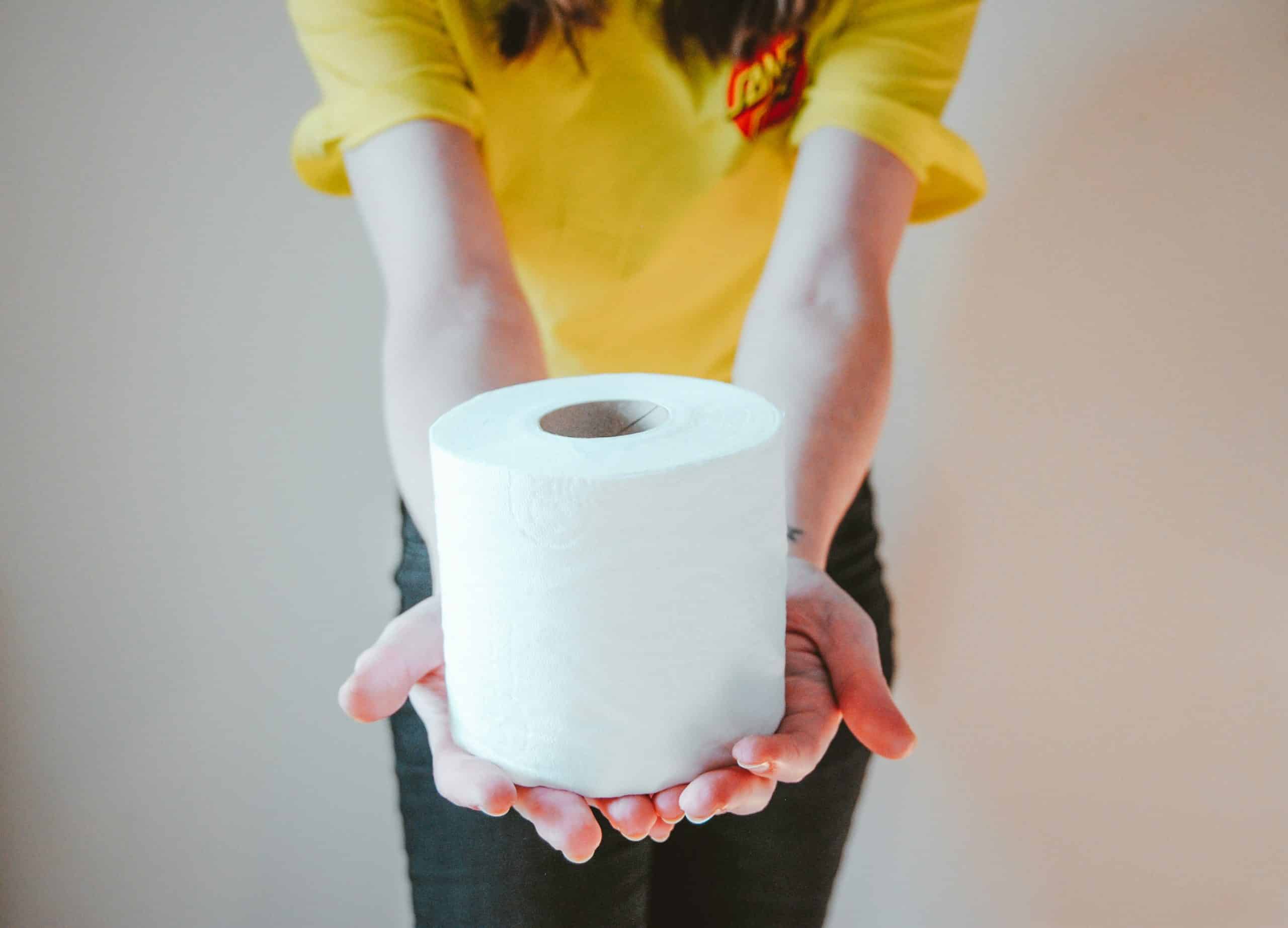 Symbolbild zum Thema Verdauung und Verstopfung: Eine Person streckt dem Betrachter eine Rolle weißes Toilettenpapier in beiden Händen entgegen.