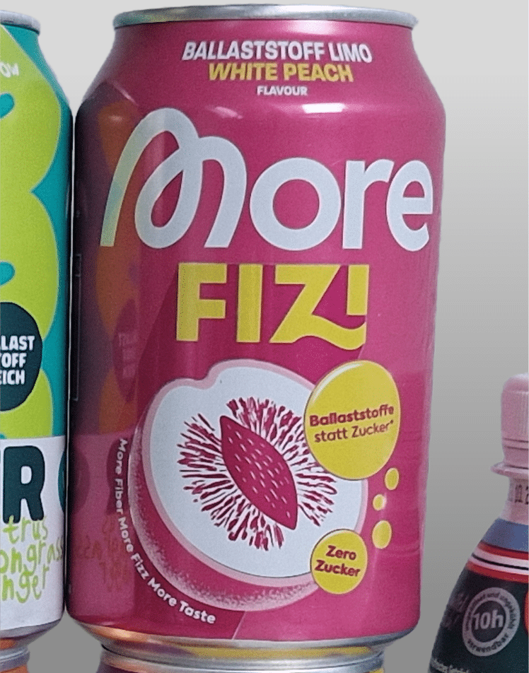 Nahaufnahme einer More FIZI Dose in der Sorte White Peach. Auf der rosafarbenen Dose stehen prominent die Werbeaussagen „Ballaststoffe statt Zucker“ und „Zero Zucker“.